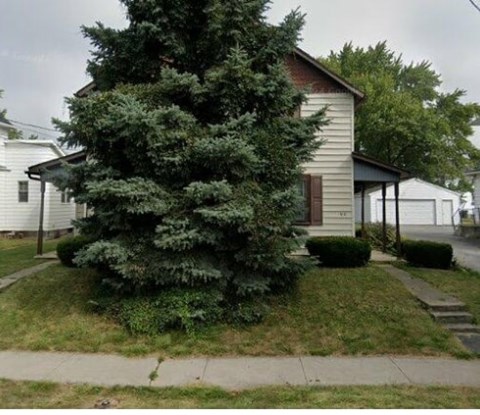 A house with a tree in front of it.