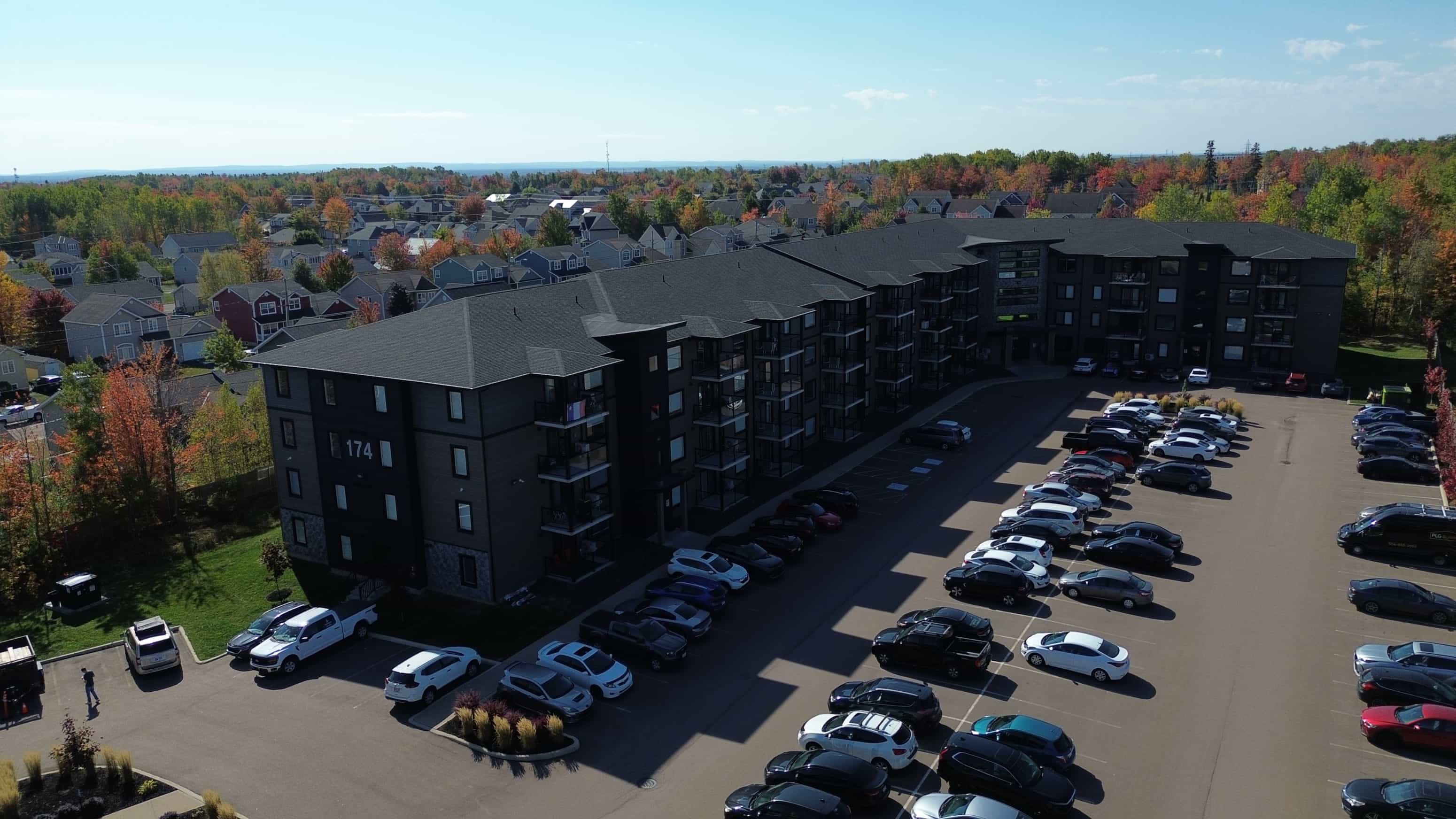 A parking lot with cars and a building in the background.