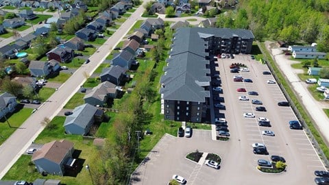 A parking lot with cars and a building in the background.