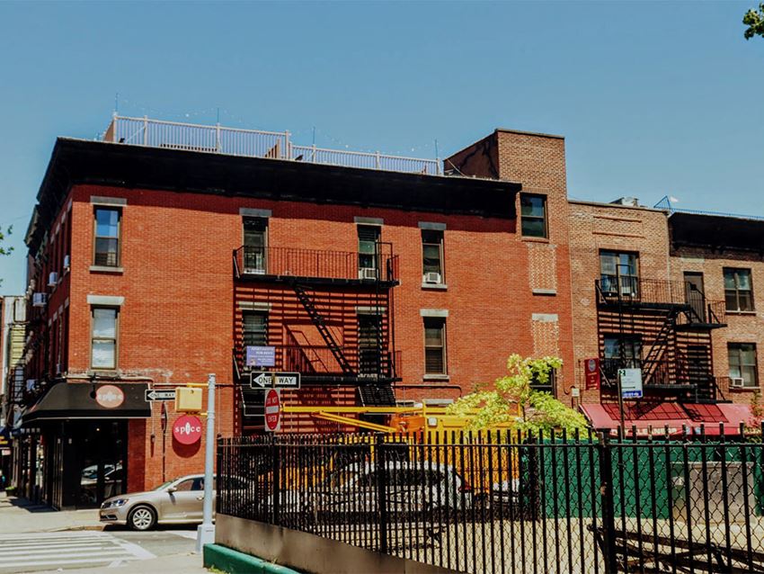 a red brick building with fire escapes on a city street