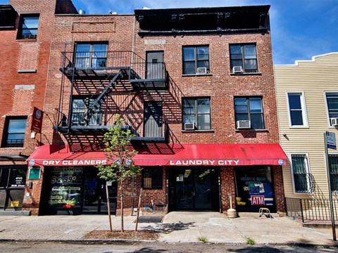 a brick building with a red awning and a fire escape