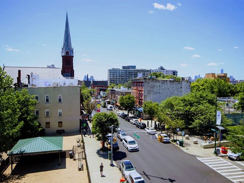 an aerial view of a city street with cars and a church tower