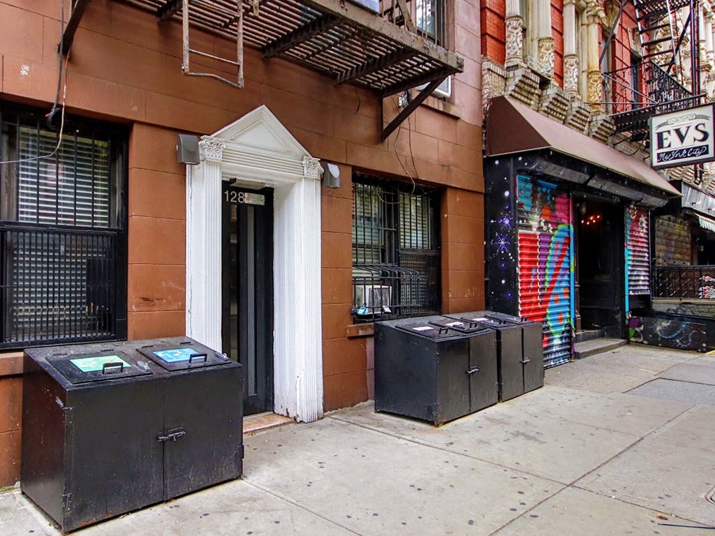 the facade of a building with three boxes on the sidewalk