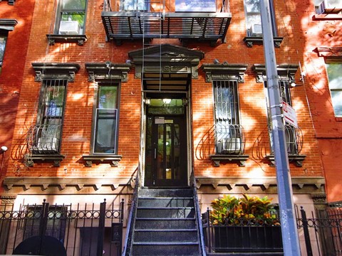 A red brick building with a black door and windows.