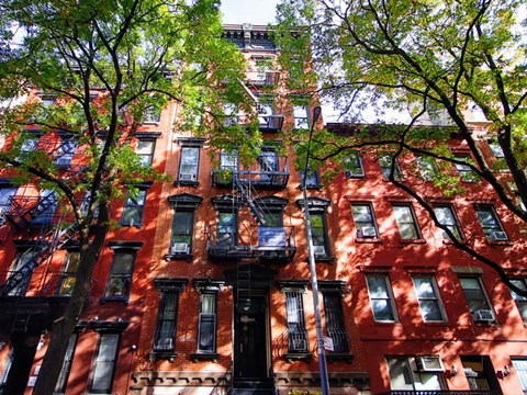 A red brick building with black fire escapes.