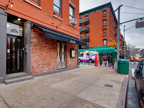 a city street with a red brick building and a food truck