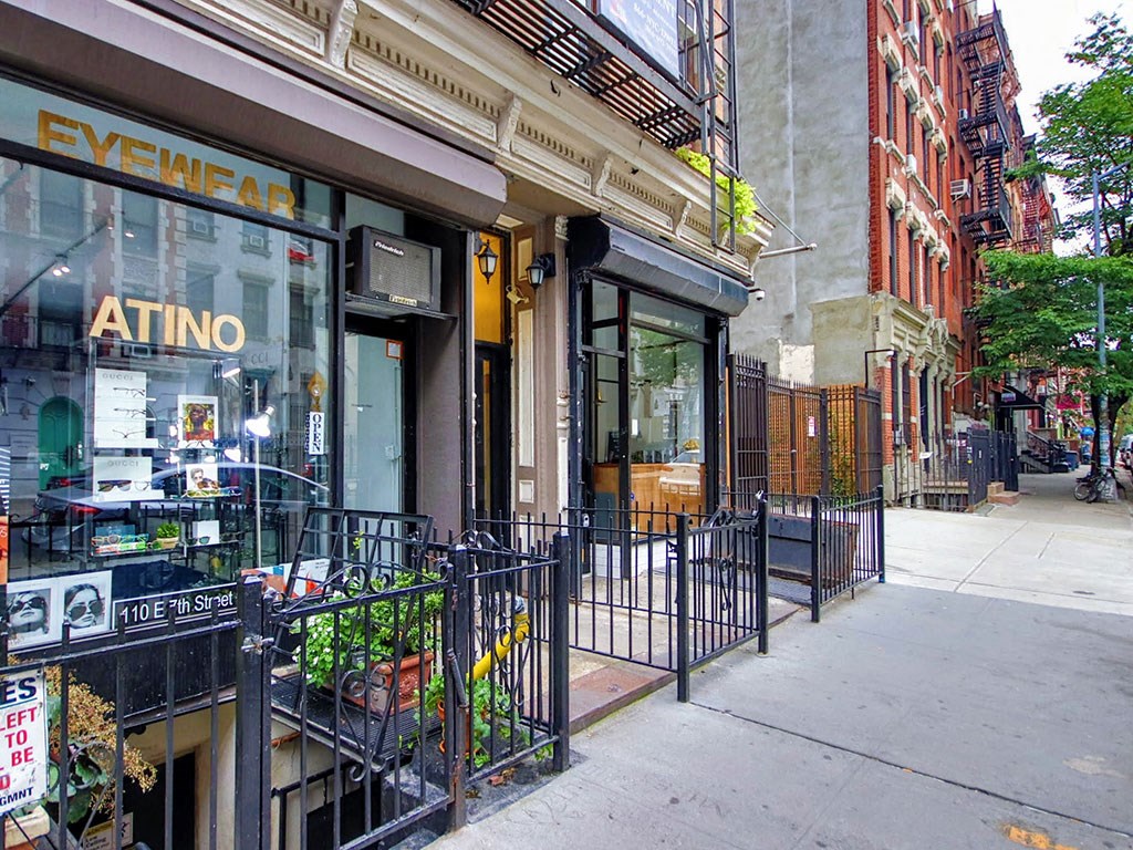 a sidewalk in front of a store on a city street