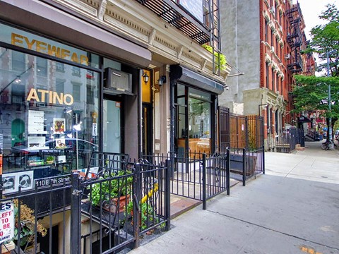 a sidewalk in front of a store on a city street