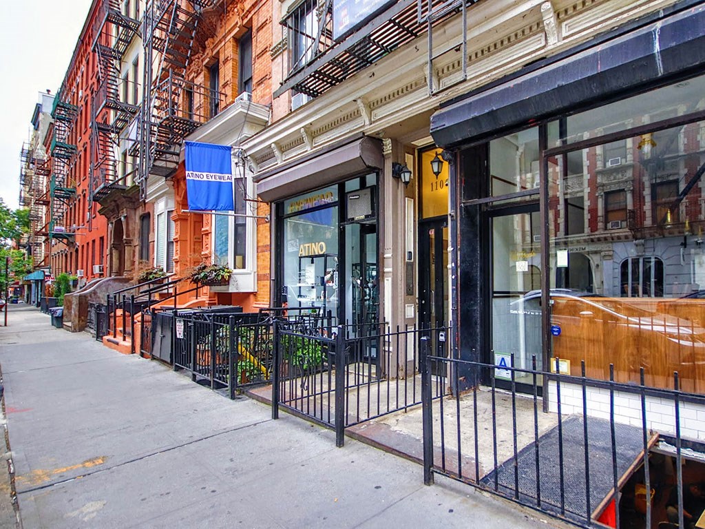 a sidewalk in front of a store on a city street