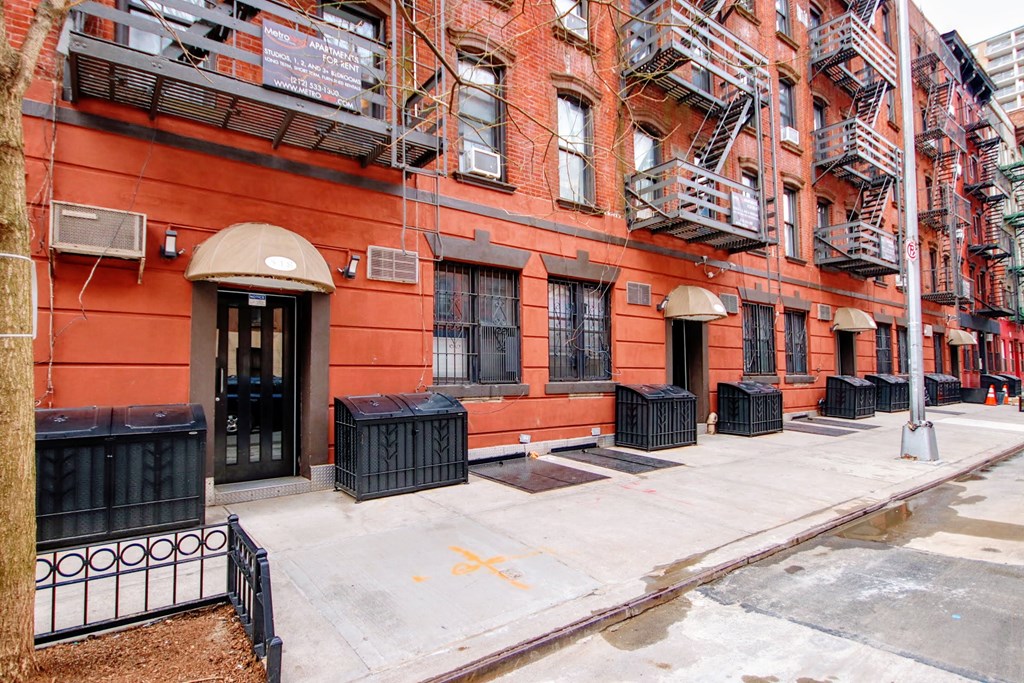 the front of a red building with a sidewalk in front of it