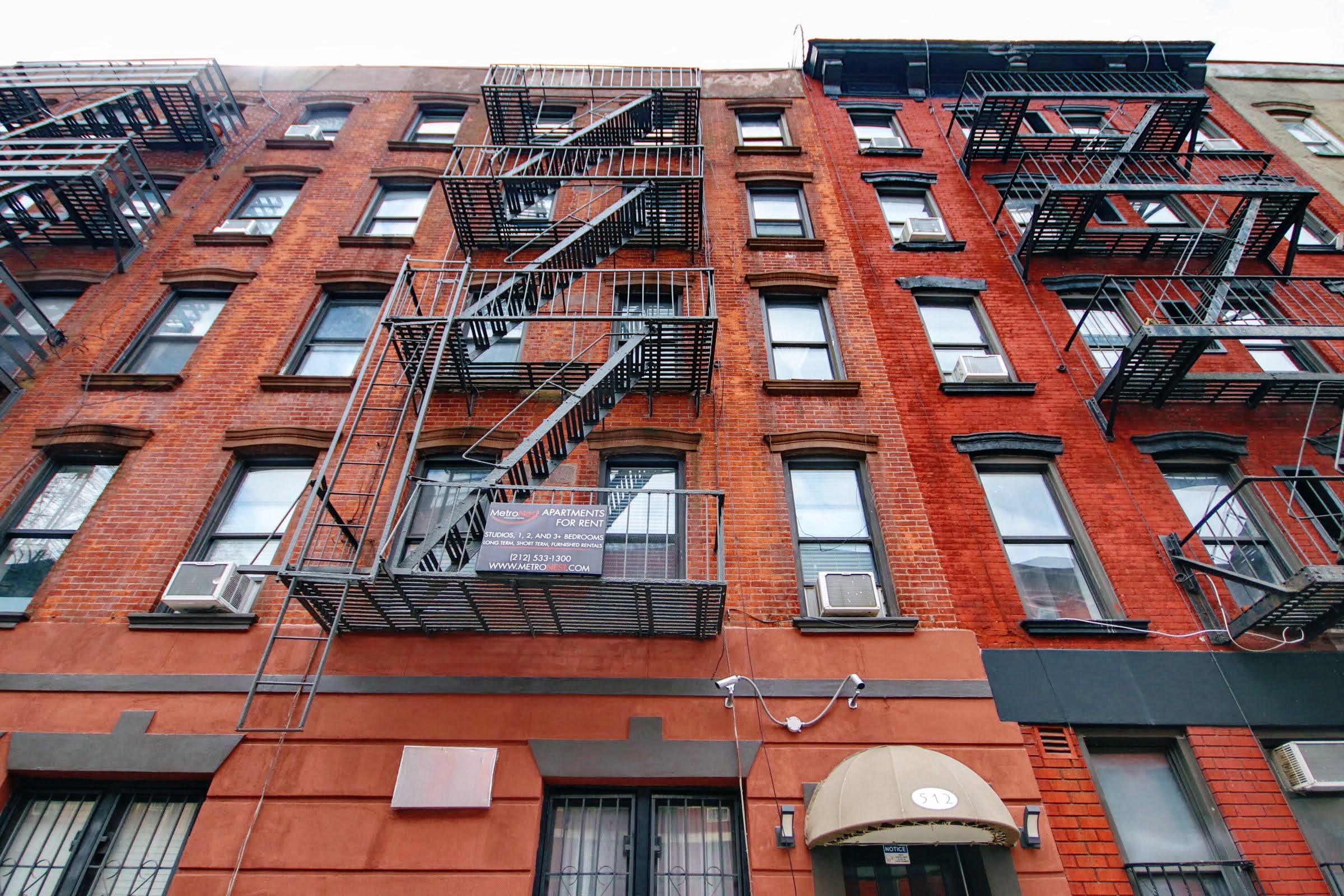 a red brick apartment building with fire escapes