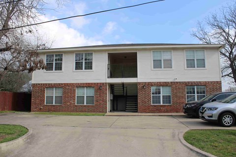 A two-story brick building with a white front and a garage door.