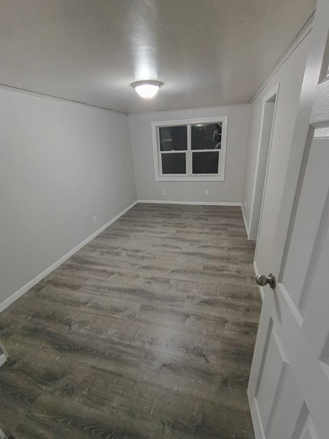 A room with a wooden floor and a window.