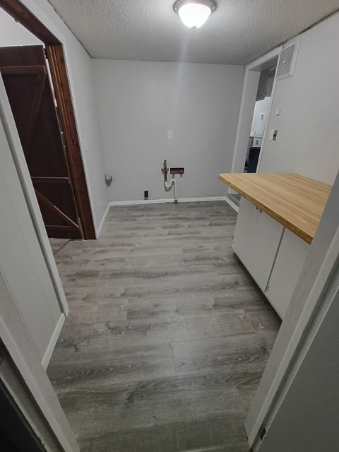 A room with a wooden floor and a white wall.