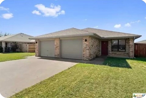 A house with a red door and a garage door.