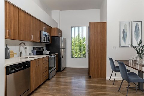 A kitchen with wooden cabinets and a black fridge.