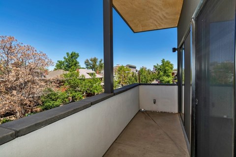 A balcony with a view of trees and houses.