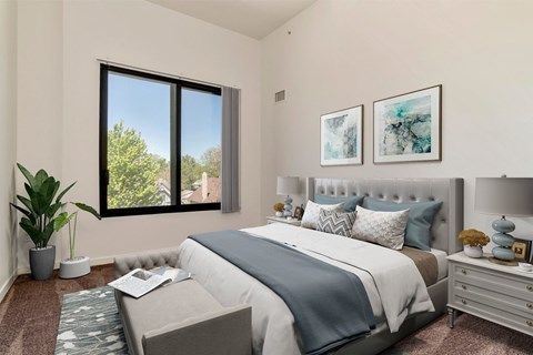 A bedroom with a large bed and a window overlooking a tree.