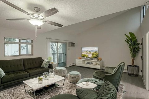 A living room with a green couch and a white coffee table.