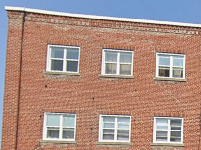 A red brick building with six windows.