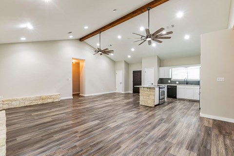 A spacious room with wooden flooring and a ceiling fan.