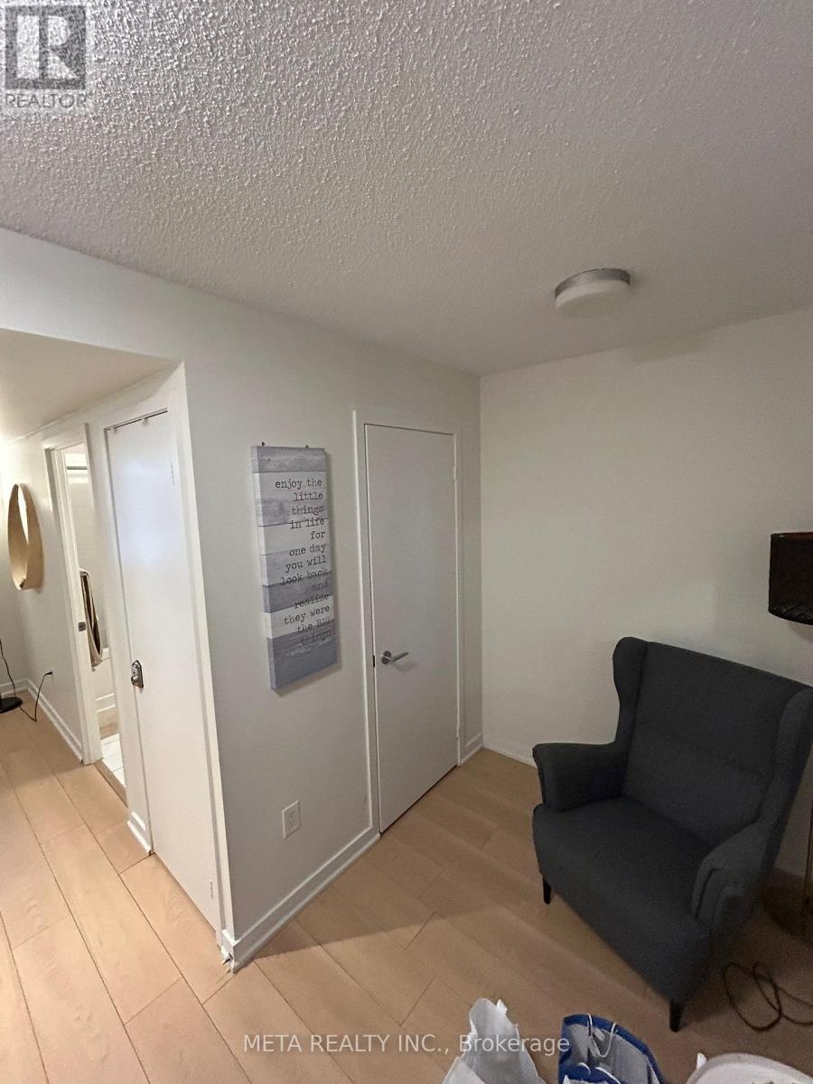 A room with a grey chair and a sign on the wall.