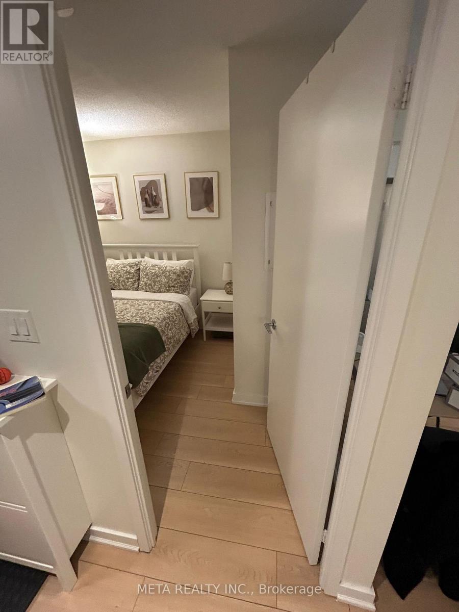 A bedroom with a bed and a nightstand.