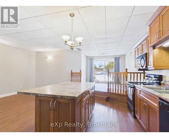 A kitchen with wooden cabinets and a black refrigerator.