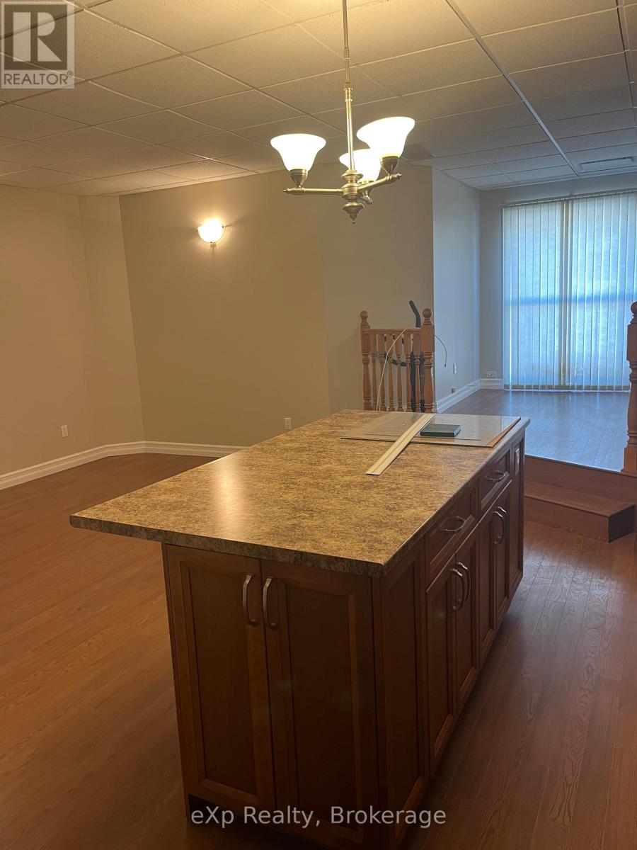 A kitchen with a granite countertop and wooden cabinets.