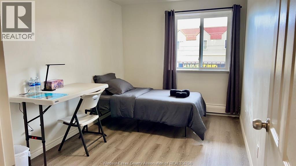 A bedroom with a bed, desk, and chair.
