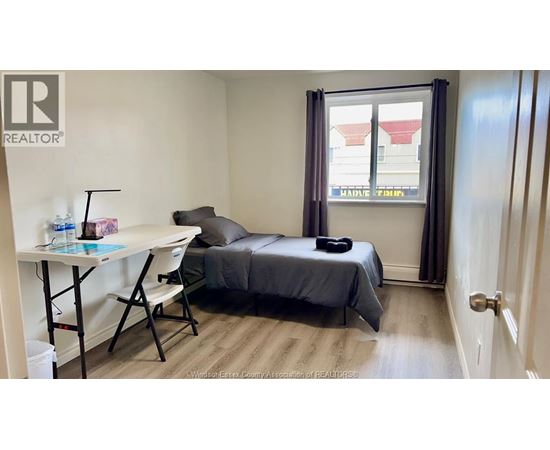 A bedroom with a bed, desk, and chair.