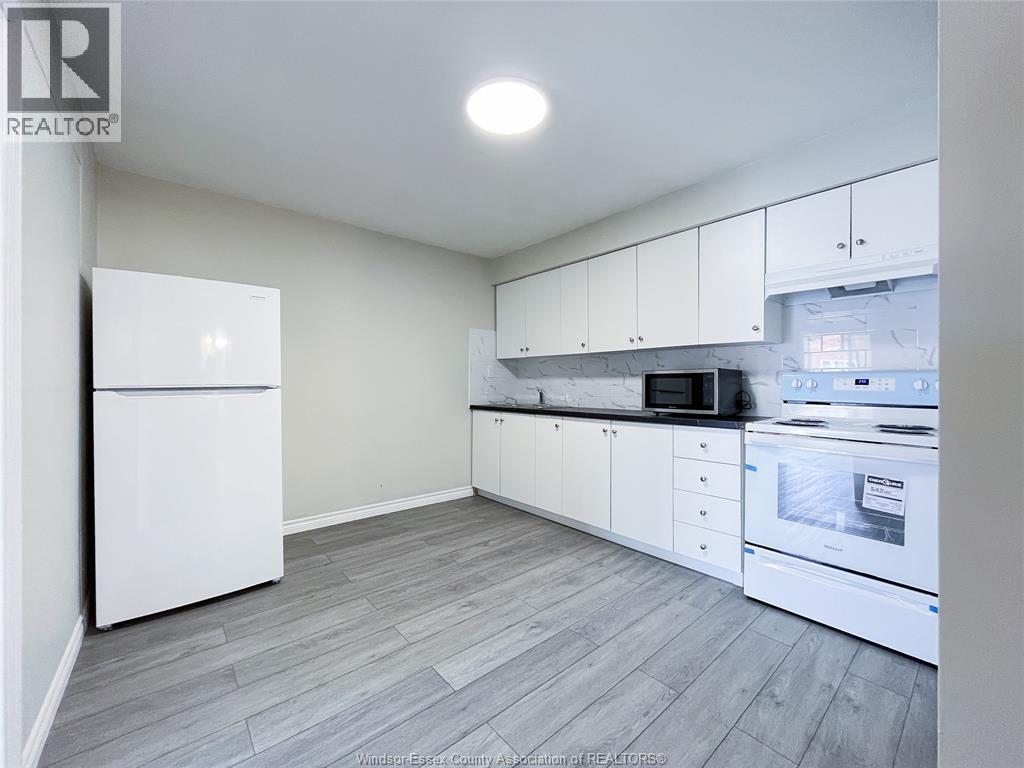 A kitchen with white appliances and cabinets.