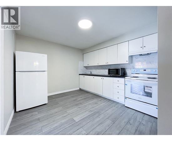 A kitchen with white appliances and cabinets.