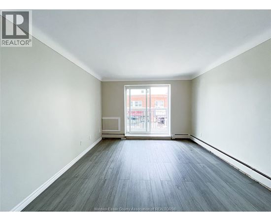 A spacious room with a view of a building outside the window.