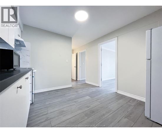 A kitchen with white cabinets and a black countertop.