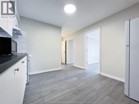 A kitchen with white cabinets and a black countertop.