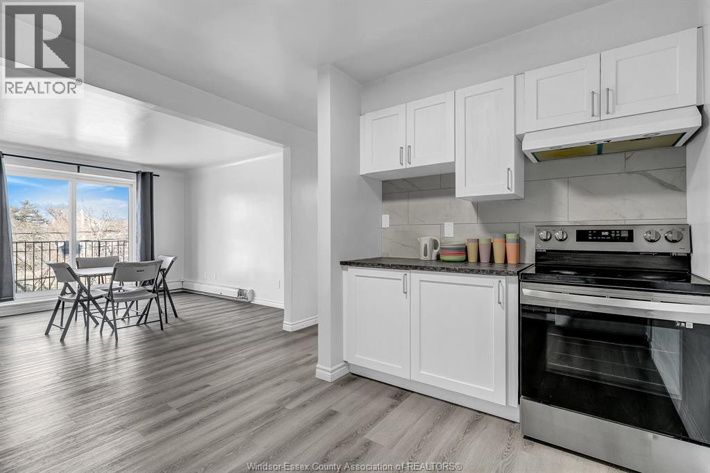 A kitchen with white cabinets and a stainless steel oven.