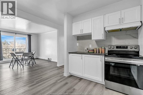 A kitchen with white cabinets and a stainless steel oven.