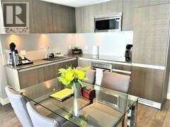 A modern dining room with a glass table and chairs.