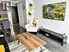 A living room with a couch, a coffee table, and a large painting on the wall.