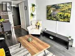 A living room with a couch, a coffee table, and a large painting on the wall.