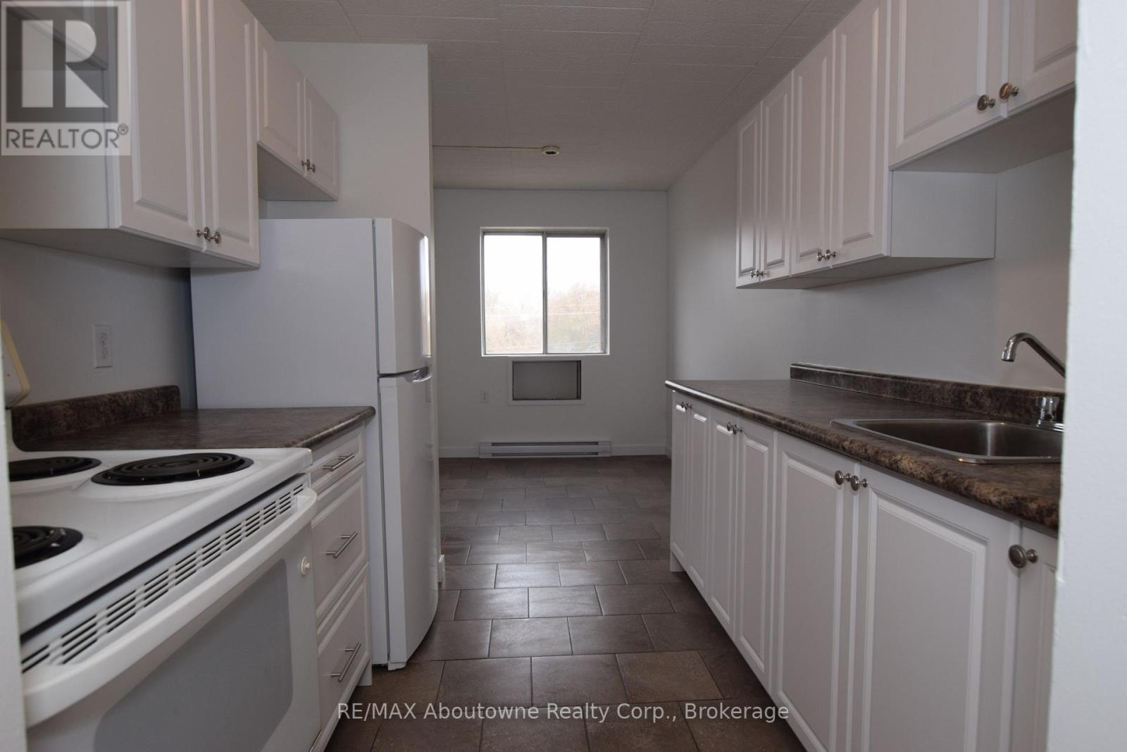 A kitchen with white cabinets and a white stove top oven.