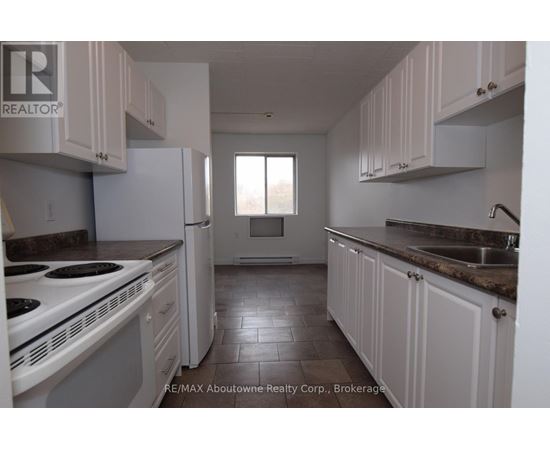 A kitchen with white cabinets and a white stove top oven.