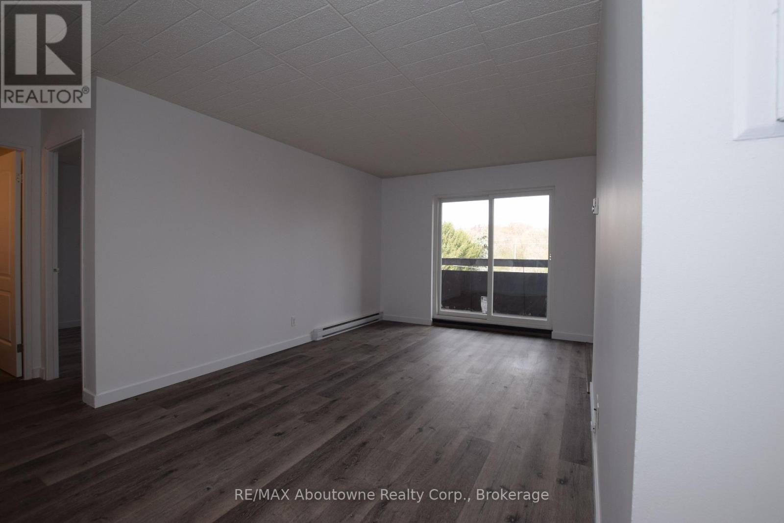 A room with a window and wooden flooring.
