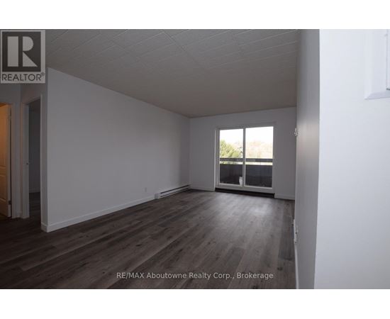 A room with a window and wooden flooring.