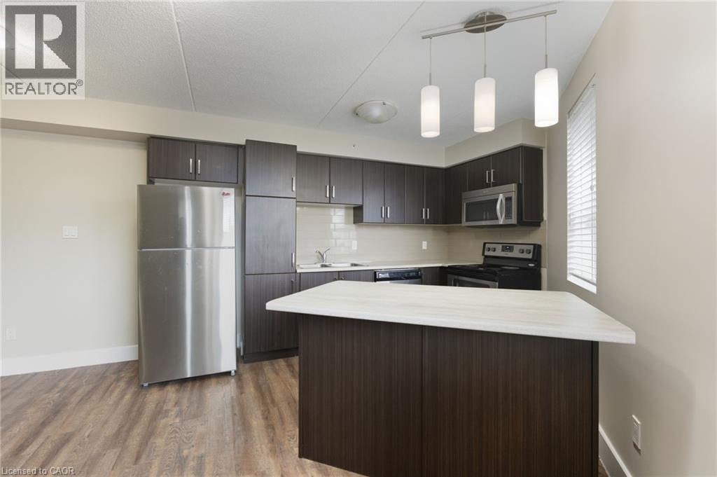 A kitchen with a stainless steel refrigerator and wooden cabinets.