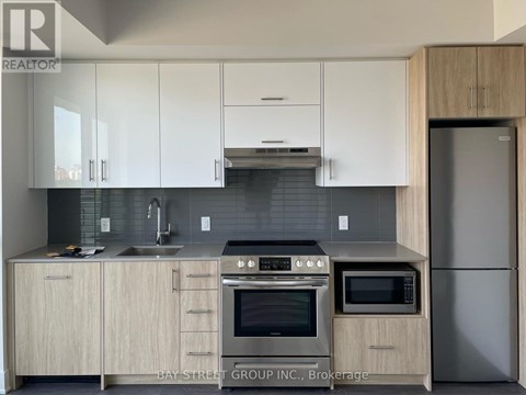 A modern kitchen with white cabinets and stainless steel appliances.