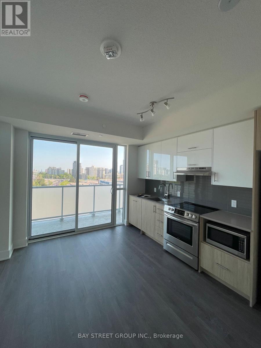 A spacious kitchen with stainless steel appliances and a view of the city.