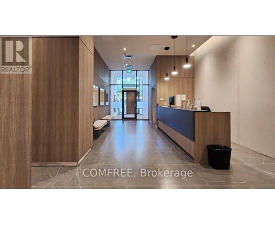 A reception area with a wooden wall and a black trash bin.