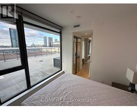 A bedroom with a large bed and a view of the city through the window.